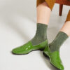 Ops&Ops No10 Avocado patent leather flats close-up seen here with green lurex socks and cropped khaki trousers