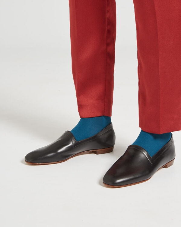 Ops&Ops No10 Classic Black leather flats close-up worn with rust-coloured slim-leg trousers and teal socks