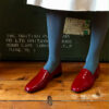 No11 Crimson patent leather loafers paired with petrol blue tights and cream leather skirt