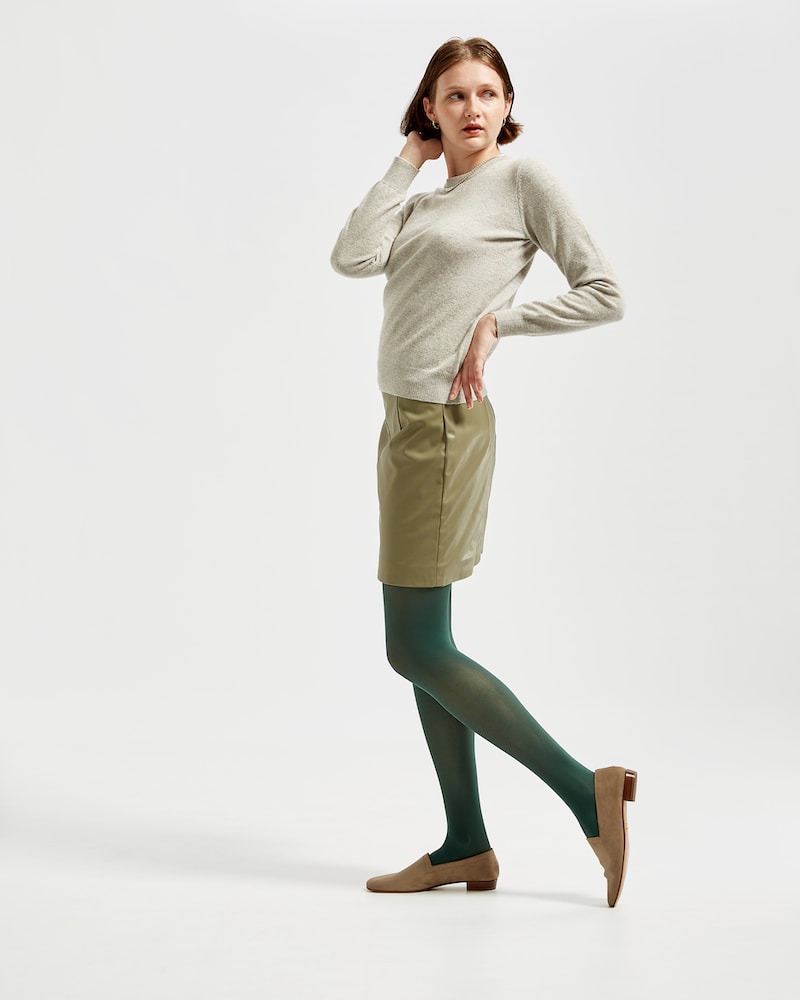 Marla in Ops&Ops No17 Mushroom flats with bottle green tights, short putty-coloured vinyl skirt and grey sweater