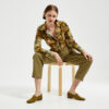 Marla sitting in Ops&Ops No17 Olive nubuck flats with olive-coloured pleated trousers and vintage Warehouse teddy bear patterned shirt