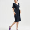 Marla in Ops&Ops No17 Woodland Blue flats with belted navy blue dress, looking over her shoulder