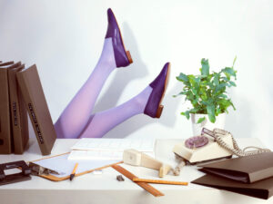 Ops&Ops No10 Royal Purple leather flats with lilac tights, feet in the air behind a dest with phone off the hook