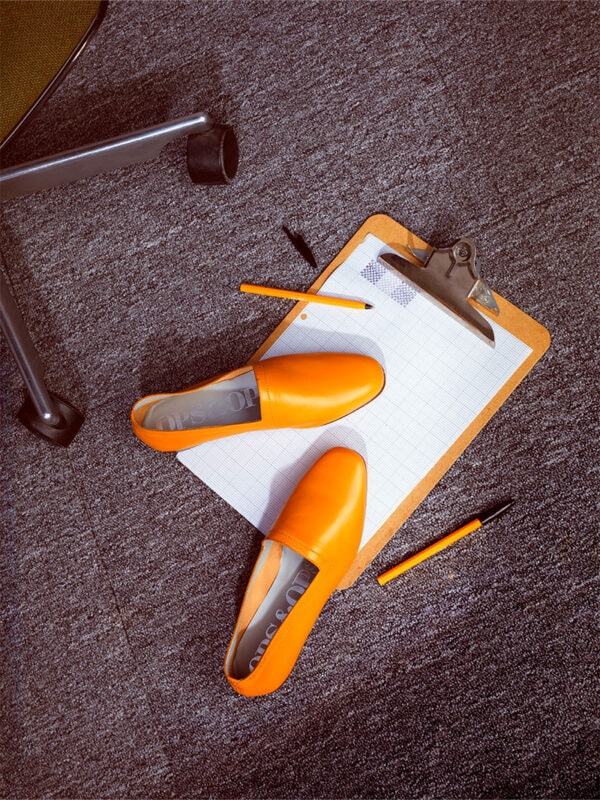 Ops&Ops No10 Turmeric leather flats shot with clipboard, pens and office chair. Photo: Lydia White