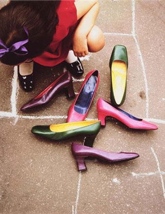 Guy Bourdin 75. Kid playing hopscotch with shoes in front