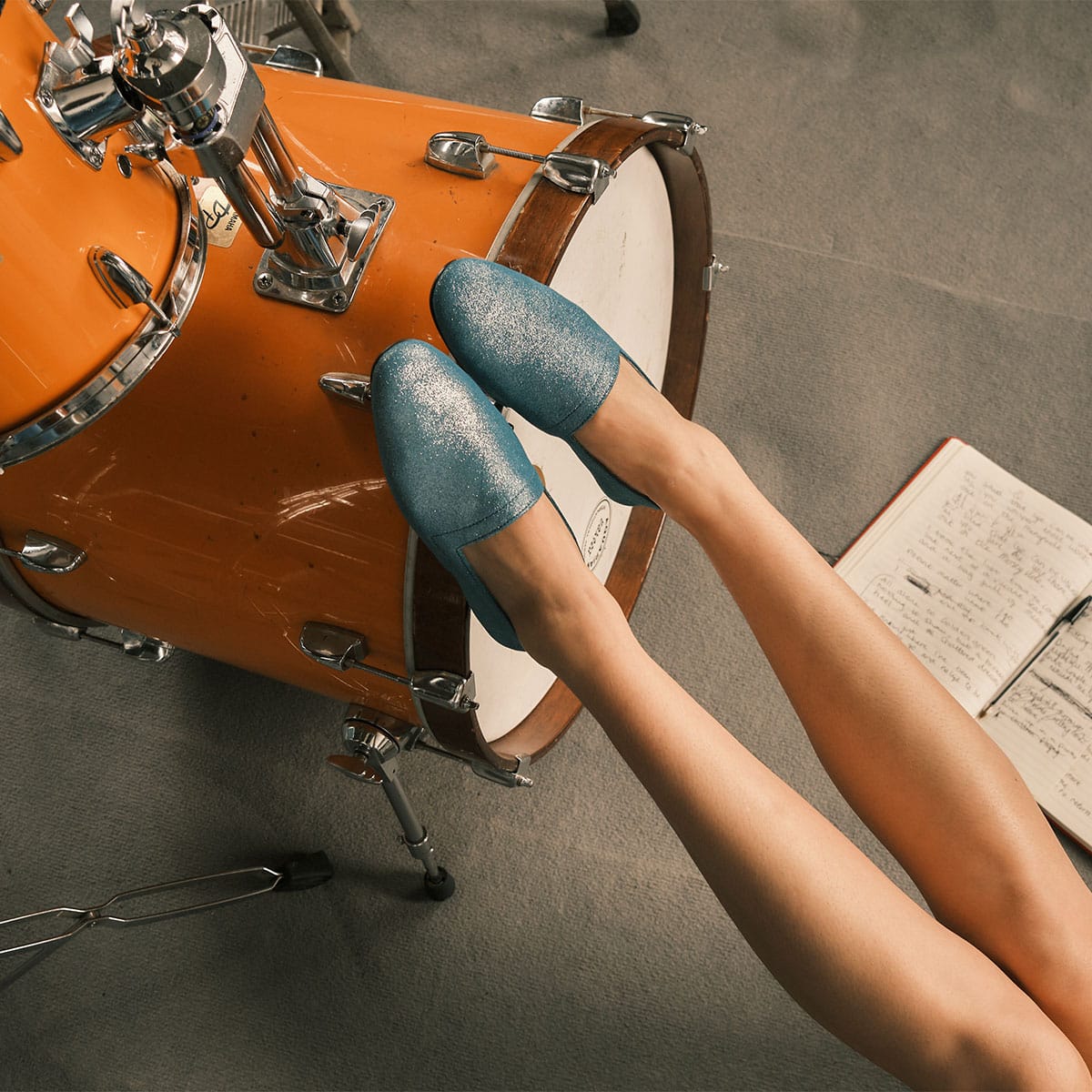 Hannah Hu wearing No10 Lurex Blue flats with feet on a drumkit