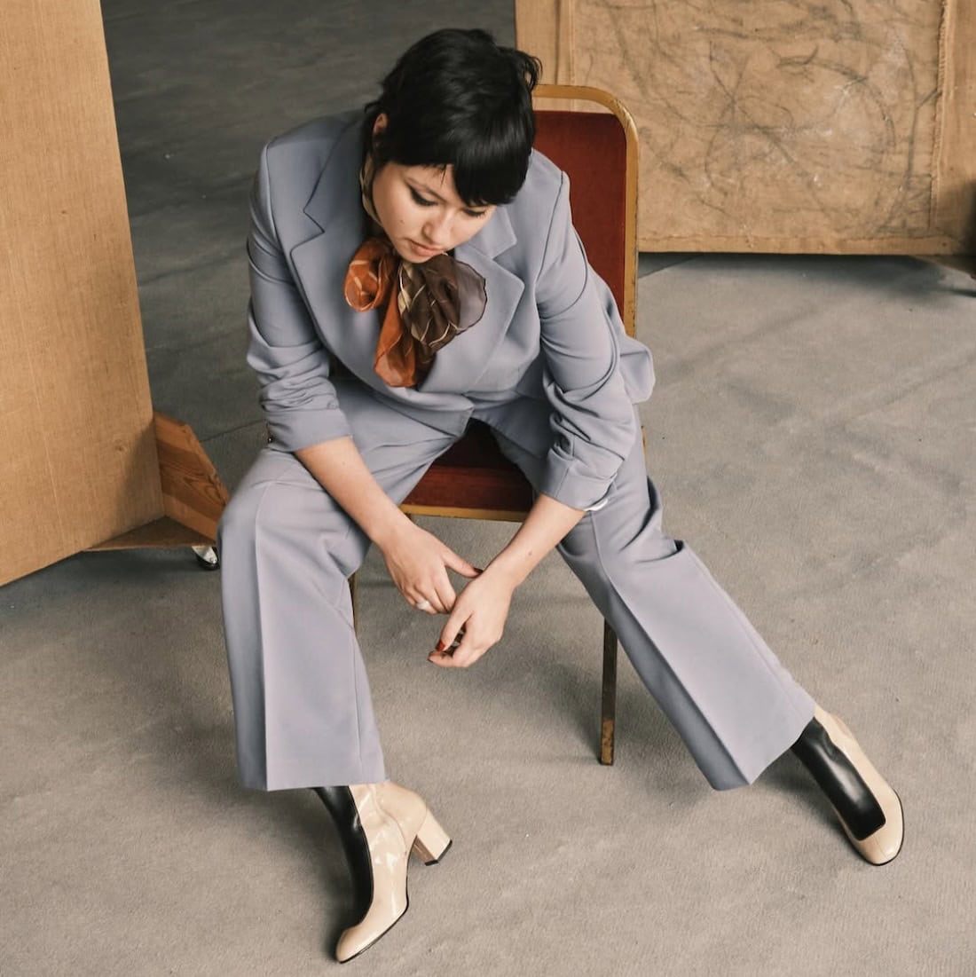 Musician Hannah Hu wearing Ops&Ops No16 Slick Sandstone boots with blue trouser suit